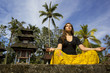 caucasian woman meditating yoga in balinese temple