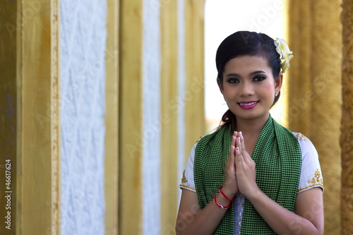 Photo: Asian Girl Greets in temple traditional way with both hands Asian Girl Greets in temple traditional way with both hands