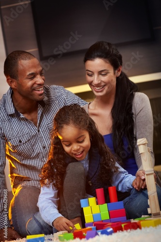 Photo: Interracial family at home playing smiling Interracial family at home playing smiling