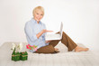 Ältere Dame mit Laptop auf dem Bett