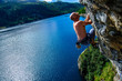 Climber climbing a rock wall above Lake Devero, Northern Italy