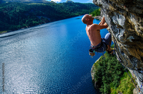 Photo: Climber climbing a rock wall above Lake Devero, Northern Italy Climber climbing a rock wall above Lake Devero, Northern Italy