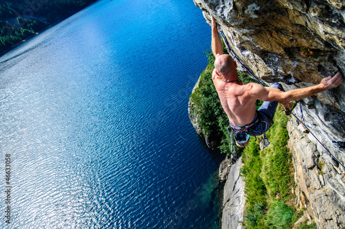 Photo: Climber climbing a rock wall above Lake Devero, Northern Italy Climber climbing a rock wall above Lake Devero, Northern Italy