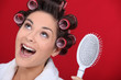 Excited brunette wearing hair-rollers