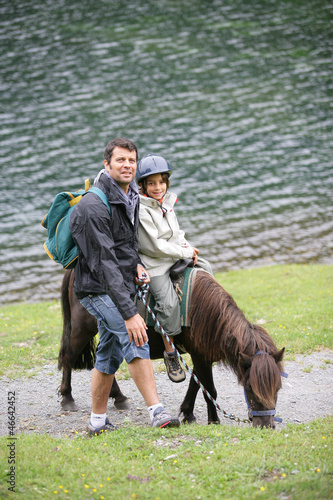 Photo: Man taking a child for a pony ride Man taking a child for a pony ride