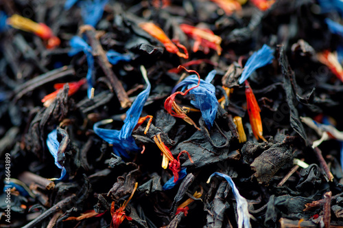 Photo: Black tea leaves and dried flowers, studio shot Black tea leaves and dried flowers, studio shot