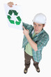 Builder pointing at recycle poster