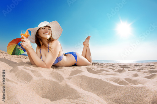 Photo: Young beautiful woman on the sand by the sea Young beautiful woman on the sand by the sea
