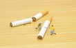 Stop smoking concept with workmen sawing cigarettes in half