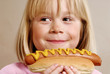 Pequeña niña comiendo perro caliente,hotdog.