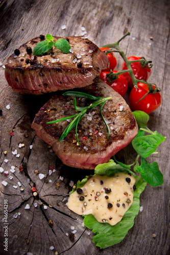 Photo: Grilled bbq steaks with fresh herbs and tomatoes Grilled bbq steaks with fresh herbs and tomatoes