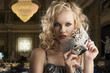blonde girl takes one silver mask with both hands