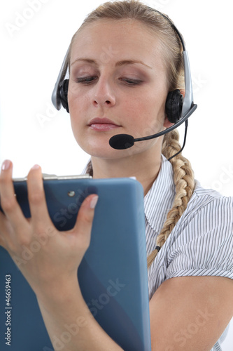 Photo: Call centre agent writing on a clipboard Call centre agent writing on a clipboard