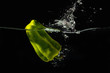 Green bellpepper falling into the water with a splash