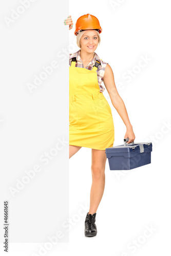 Photo: Female worker holding a tool box and posing Female worker holding a tool box and posing