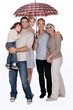 Smiling family under an umbrella
