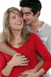 young happy couple embracing against studio background