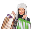 A young woman in winter clothes holding shopping bags