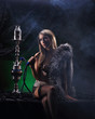 A young blond woman in erotic clothes smoking a hookah