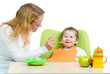 young mother spoon feeding her baby boy isolated on white