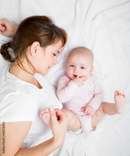 Photo: joyful mother playing with her baby infant joyful mother playing with her baby infant