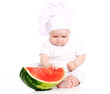 Happy baby cook eating watermelon in studio