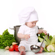 Baby cook with pan and vegetables on a white