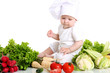 Baby cook with fresh vegetables on a white