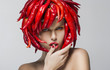 Fashion trendy woman with red chili pepper as a headwear
