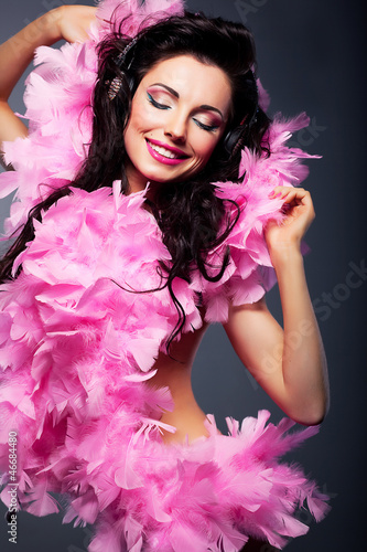Photo: Elated positive woman in pink dress listening to the music Elated positive woman in pink dress listening to the music