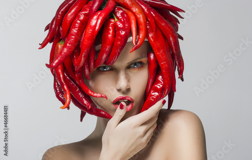Photo: Fashion trendy woman with red chili pepper as a headwear Fashion trendy woman with red chili pepper as a headwear