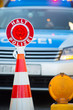 Polizeikelle auf Pilone vor Polizeiauto