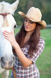 Cowgirl rubbing her horse