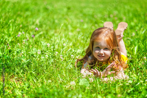 Photo: A smiling girl is lying on the meadow A smiling girl is lying on the meadow