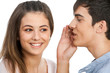 Boy whispering in cute girls ear.