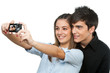 Photo: Young couple taking auto portrait with camera. Young couple taking auto portrait with camera.
