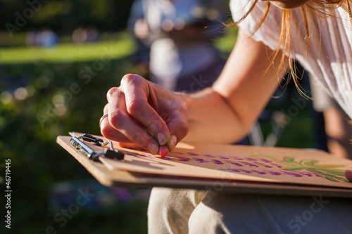 Photo: Girl draws flowers with pastels Girl draws flowers with pastels