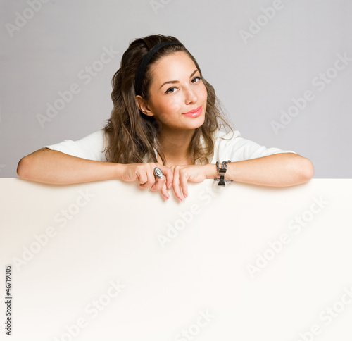 Photo: Brunette beauty with blank banner. Brunette beauty with blank banner.