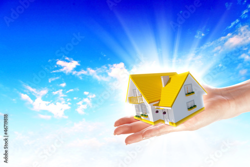 Illustration: the house in hands on blue sky the house in hands on blue sky