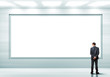 Business person standing near a blank billboard