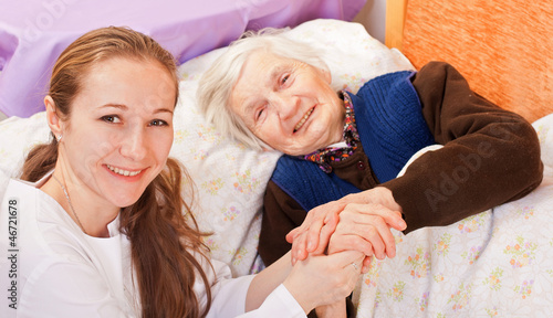 Photo: Young doctor holds the elderly woman hands Young doctor holds the elderly woman hands