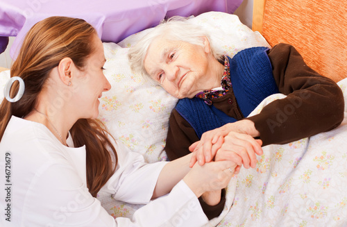 Photo: Young doctor holds the elderly woman hands Young doctor holds the elderly woman hands