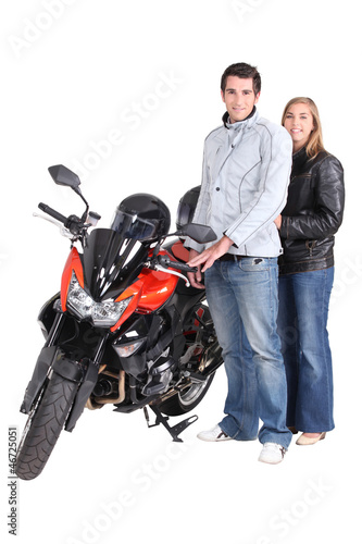 Photo: Couple stood by motorbike Couple stood by motorbike