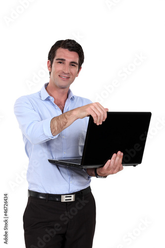 Photo: A businessman standing with his laptop. A businessman standing with his laptop.