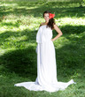 Photo: young happy woman in long white dress on natural background young happy woman in long white dress on natural background