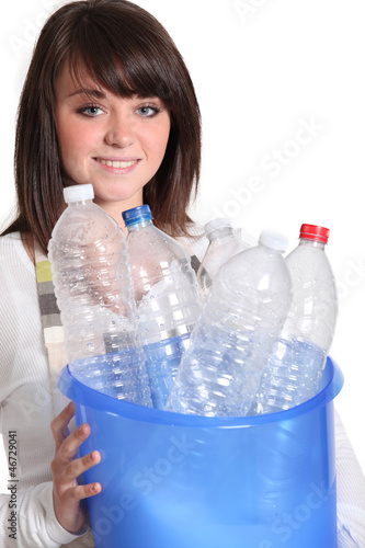 Photo: Girl carrying bucket of empty plastic bottles Girl carrying bucket of empty plastic bottles