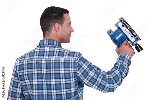 Photo: Man using powered sander Man using powered sander