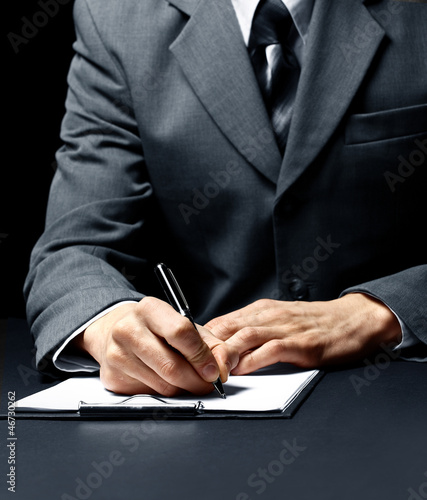 Photo: businessman signing a document businessman signing a document