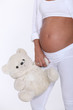 Pregnant woman holding teddy bear
