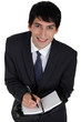 Businessman writing in agenda